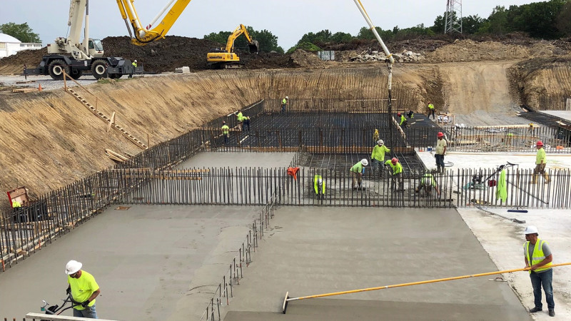Workers spreading concrete at a work site